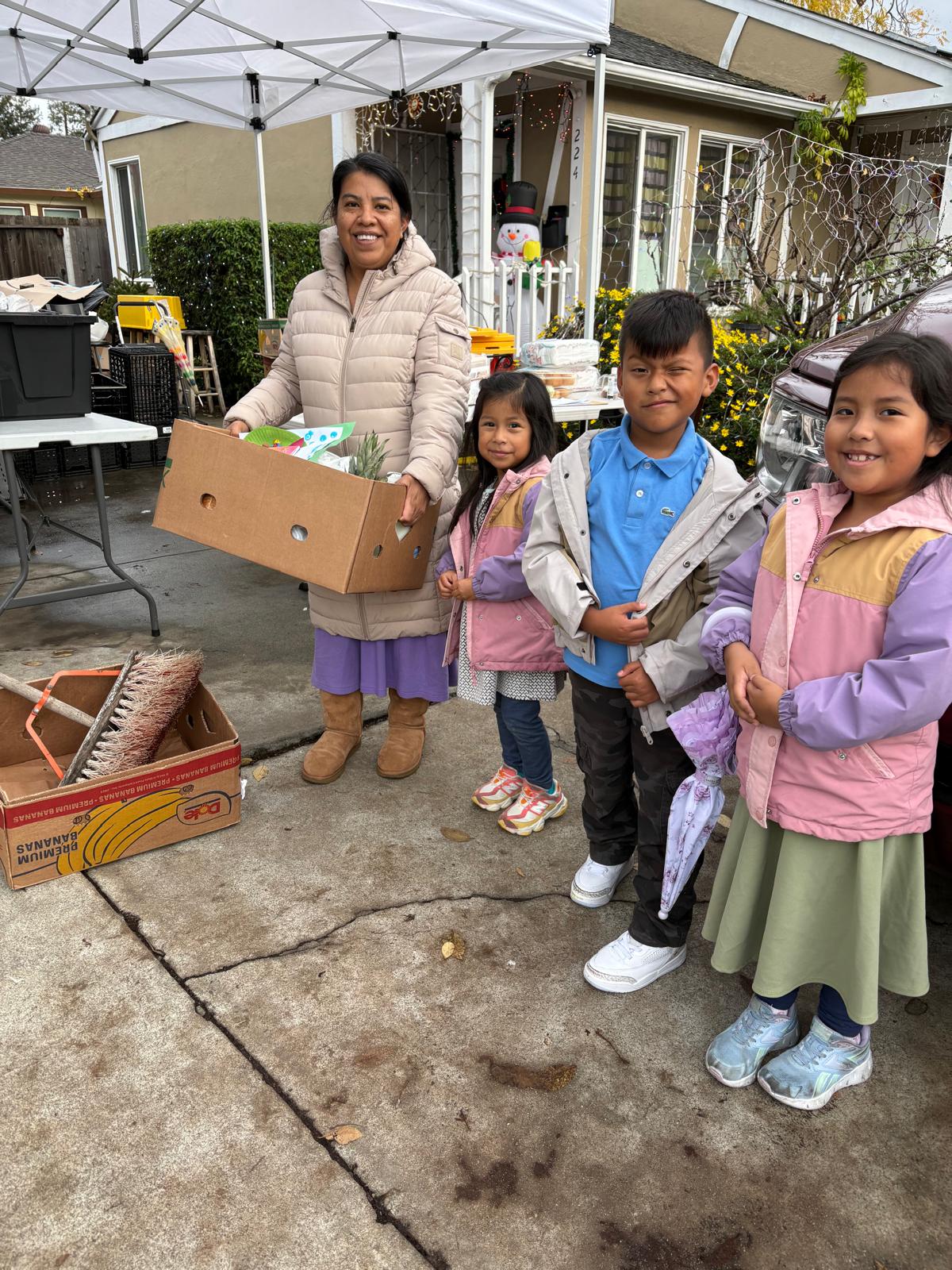 A family receiving food and supplies at a Heart to Heart community event